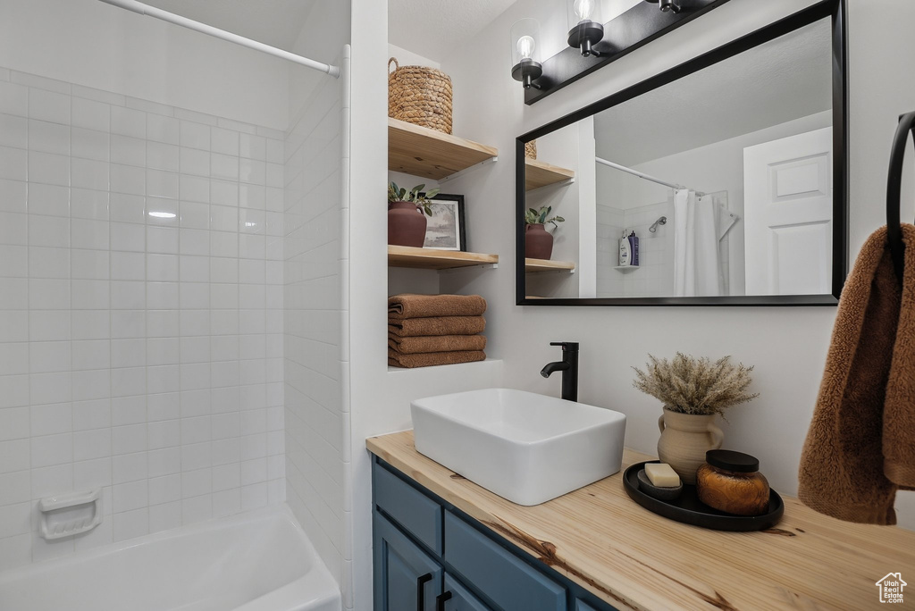 Full bathroom featuring shower / bath combination with curtain and vanity