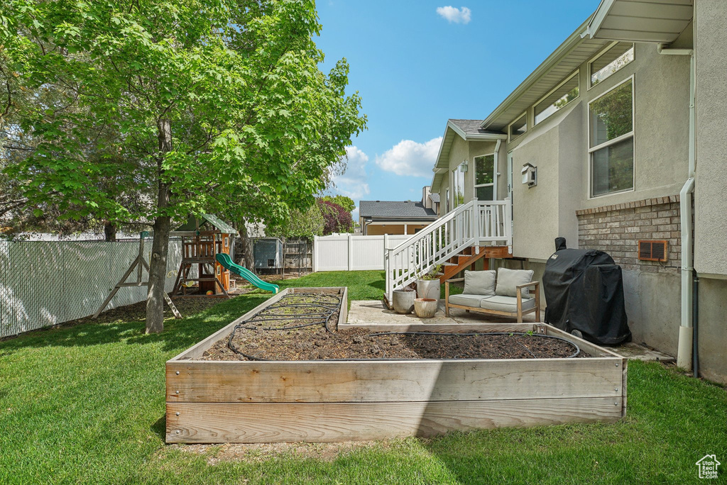 View of yard with a garden and a playground