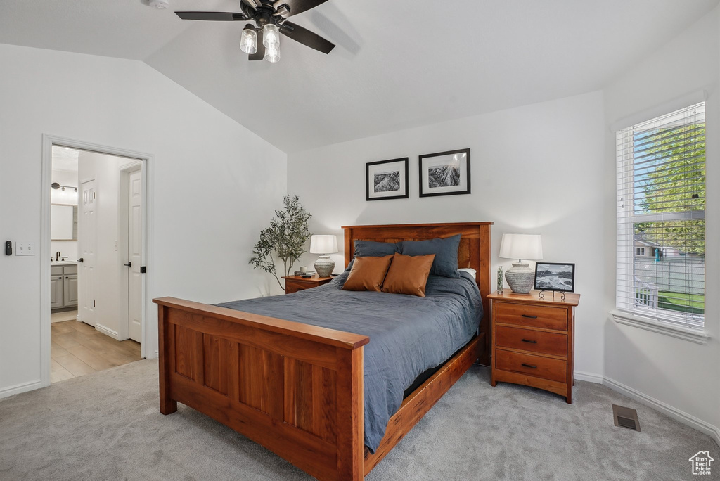Bedroom featuring carpet, vaulted ceiling, ensuite bathroom, ceiling fan, and baseboards