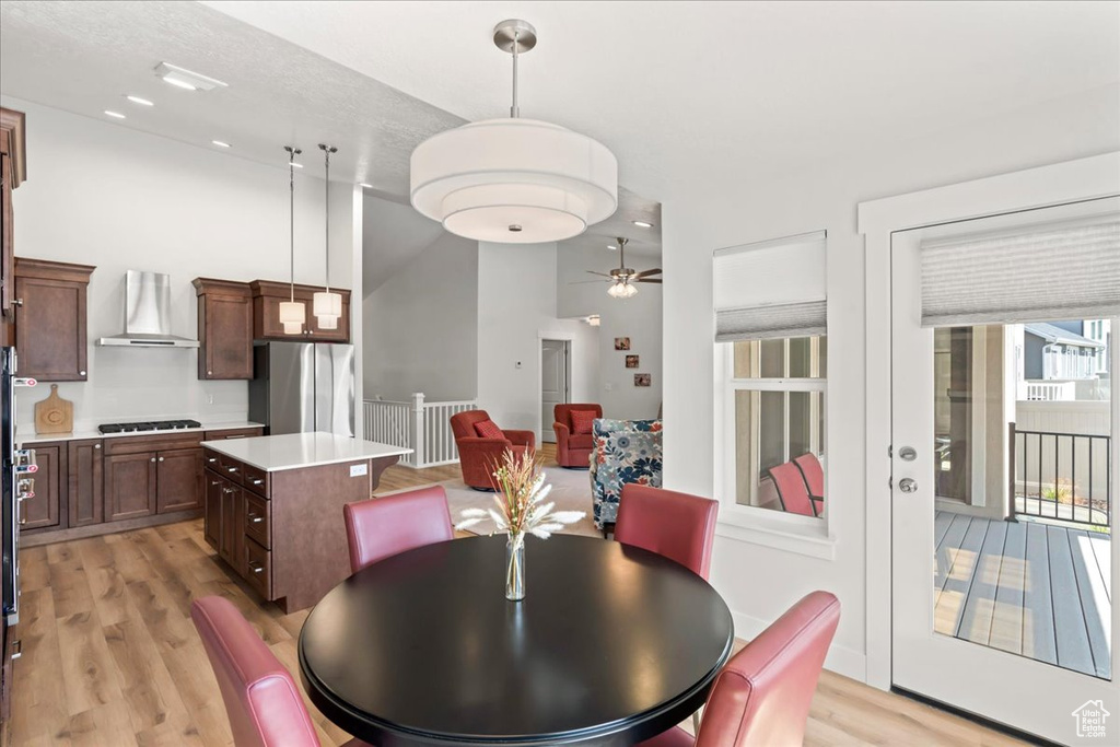 Dining room featuring ceiling fan, lofted ceiling, and light wood-style floors
