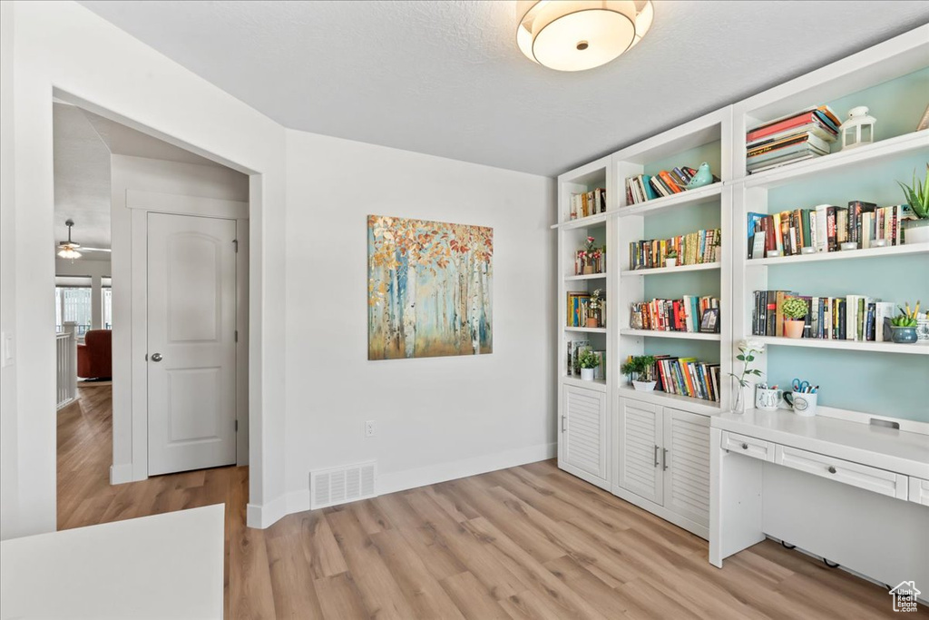 Interior space featuring baseboards, visible vents, and light wood-style flooring
