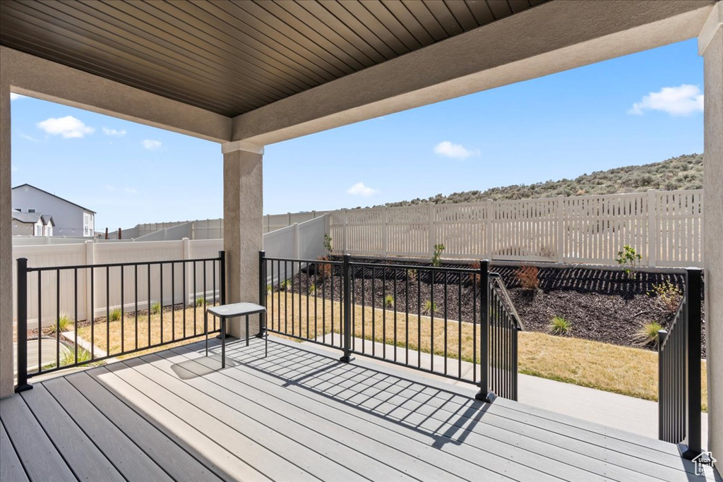 Wooden terrace with a fenced backyard and a patio area