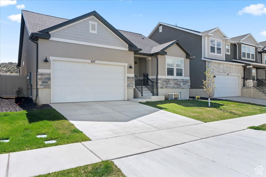 View of front of home featuring stucco siding, concrete driveway, and stone siding