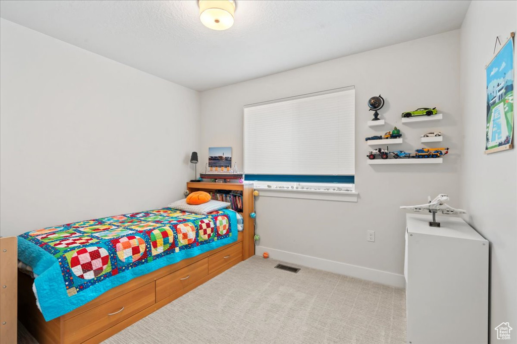 Carpeted bedroom with baseboards and visible vents