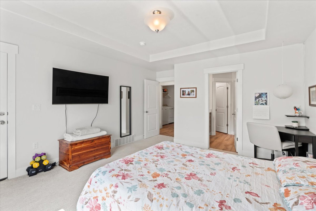 Carpeted bedroom featuring a tray ceiling