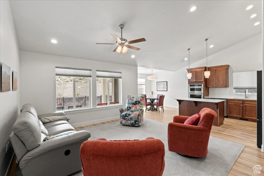 Living area featuring recessed lighting, ceiling fan, light wood-type flooring, and lofted ceiling