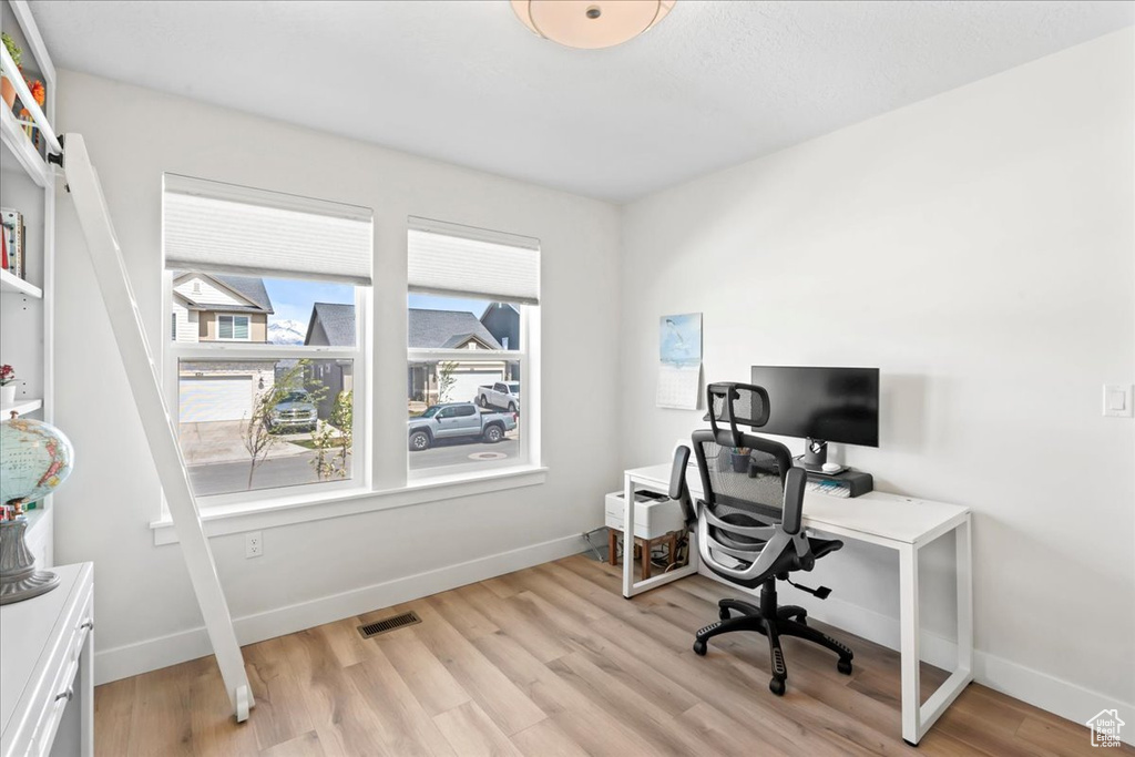 Home office featuring baseboards, visible vents, and light wood finished floors