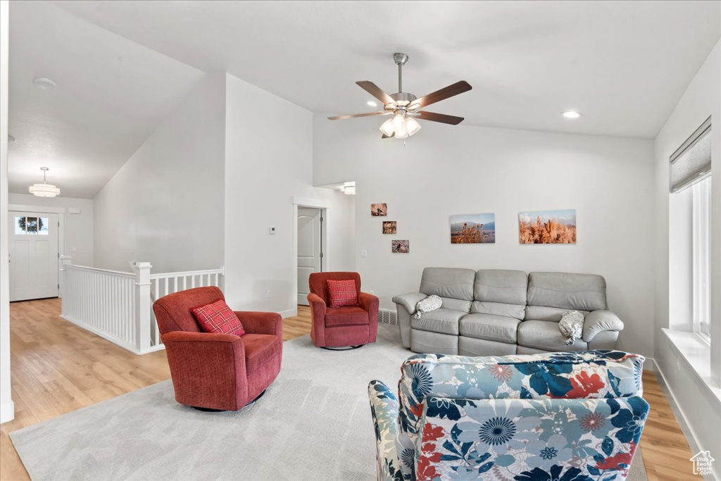 Living room with recessed lighting, a ceiling fan, wood finished floors, and high vaulted ceiling