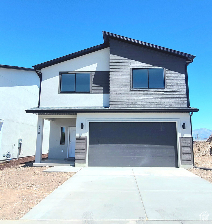 Contemporary home featuring stucco siding, an attached garage, and concrete driveway