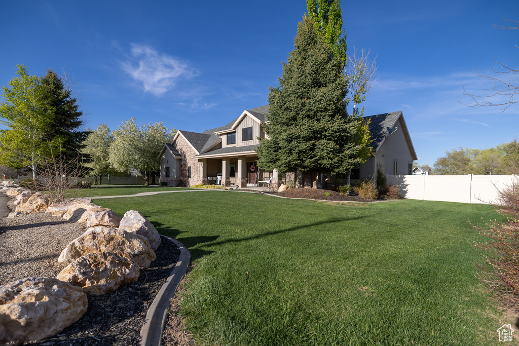 View of front of home featuring fence and a front yard