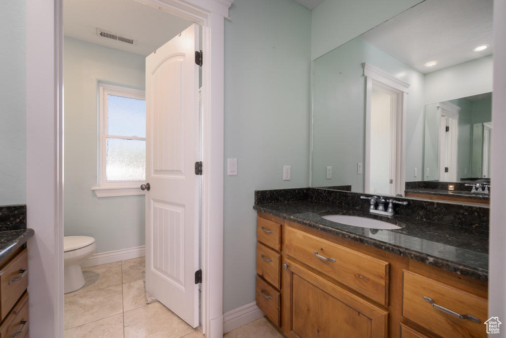Bathroom featuring visible vents, baseboards, toilet, and vanity