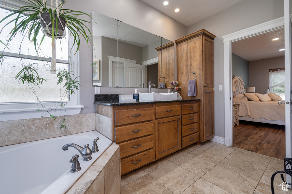 Ensuite bathroom featuring vanity, a bath, ensuite bath, and recessed lighting