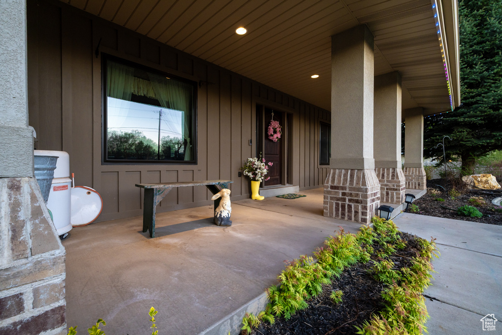 Doorway to property featuring board and batten siding and covered porch