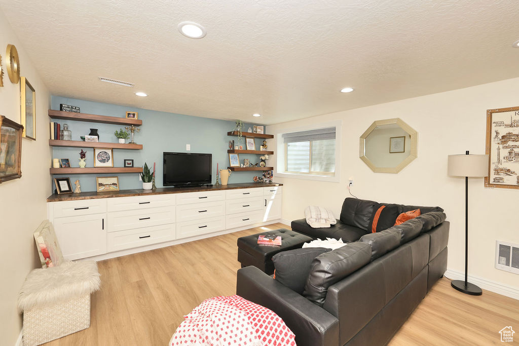 Living area with light wood-style floors, recessed lighting, and baseboards