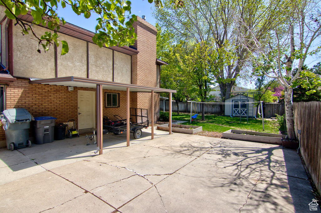 View of patio / terrace featuring a storage shed, an outdoor structure, a fenced backyard, and a grill
