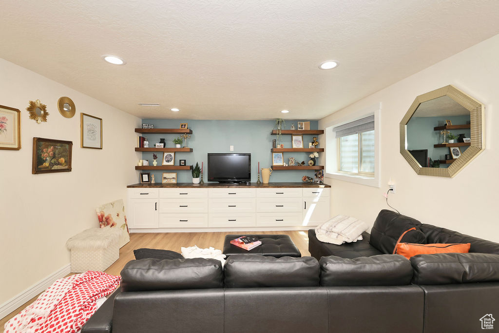 Living area featuring recessed lighting, a textured ceiling, and light wood finished floors
