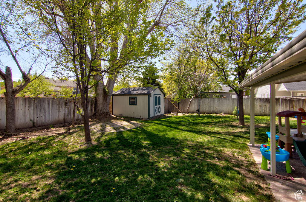 View of yard with a fenced backyard, an outbuilding, and a shed