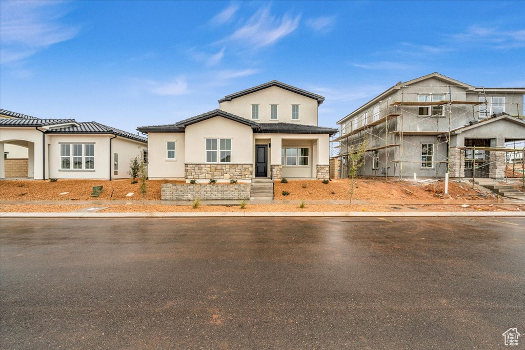 View of front of house featuring stone siding and stucco siding