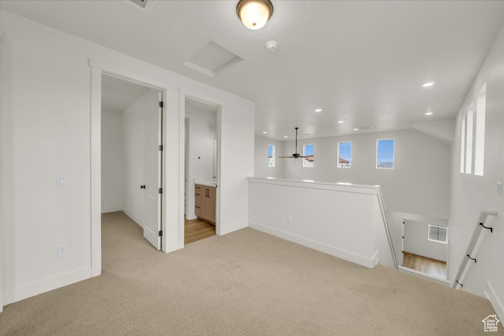 Unfurnished room with baseboards, recessed lighting, attic access, and light carpet