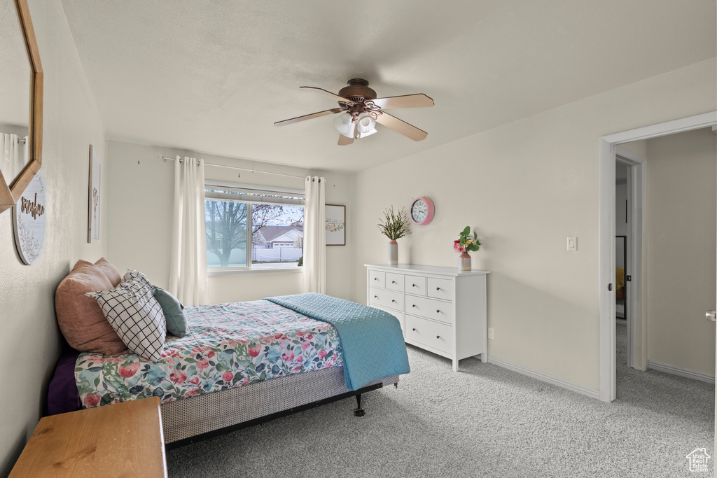 Bedroom featuring baseboards, ceiling fan, and light carpet