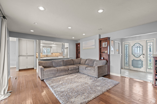 Living area with light wood-type flooring, recessed lighting, and baseboards