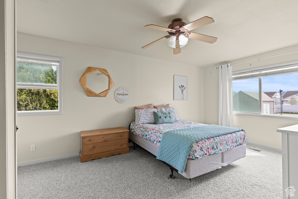 Carpeted bedroom featuring baseboards, a ceiling fan, and visible vents
