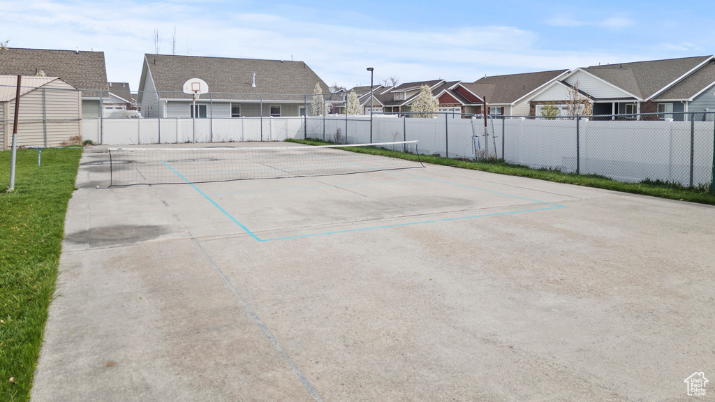View of car parking featuring a residential view, community basketball court, and fence