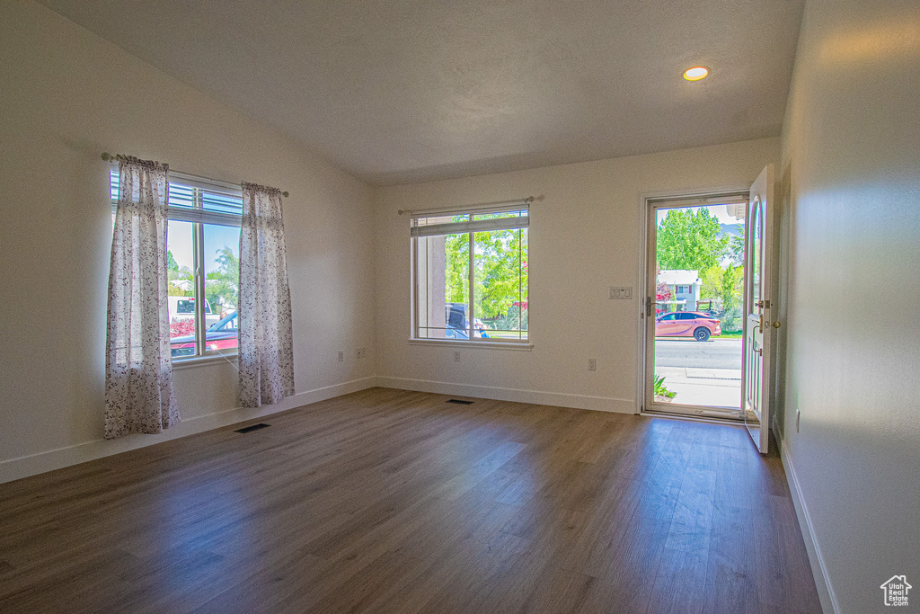 Unfurnished room with plenty of natural light, wood finished floors, and visible vents