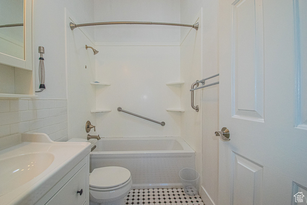Bathroom featuring shower / bathtub combination, toilet, tile patterned floors, and vanity