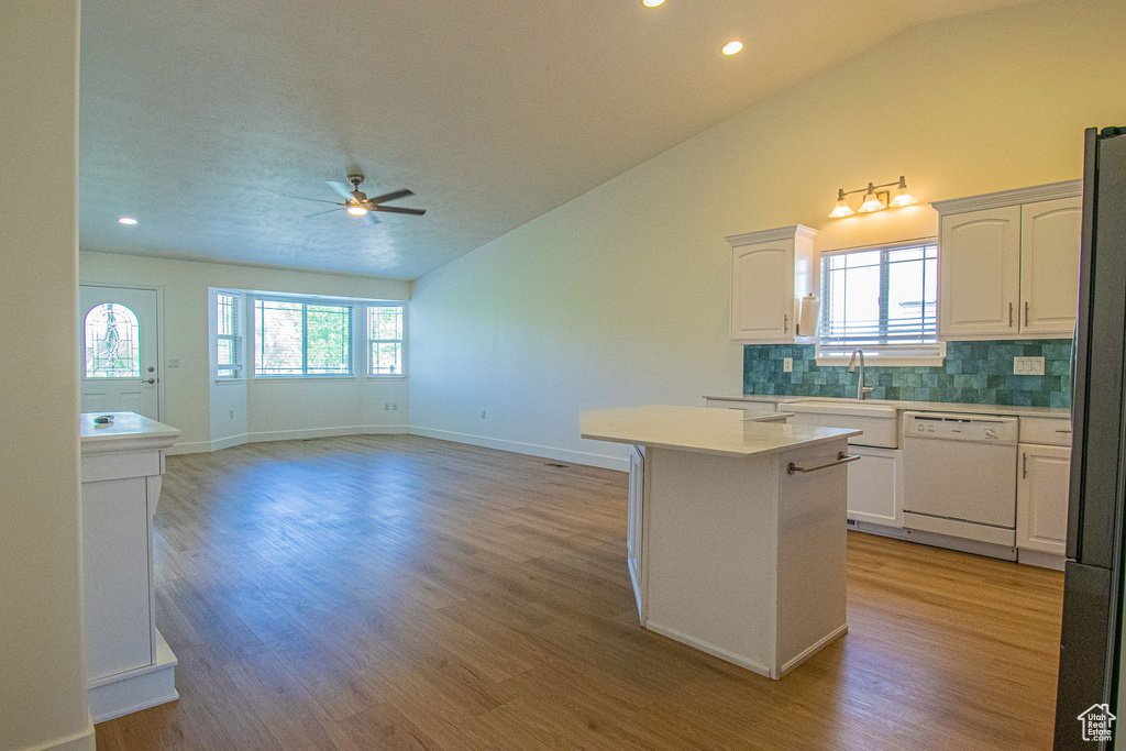 Kitchen featuring a ceiling fan, backsplash, dishwasher, and vaulted ceiling