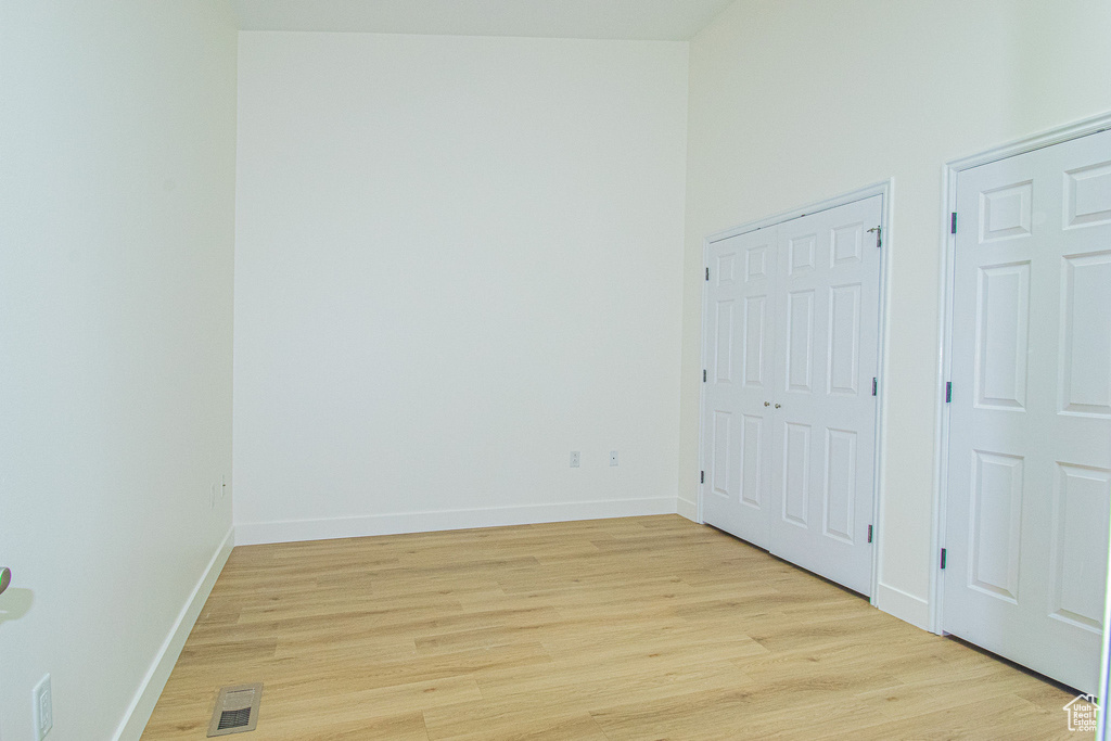 Unfurnished bedroom with baseboards, light wood-type flooring, and visible vents