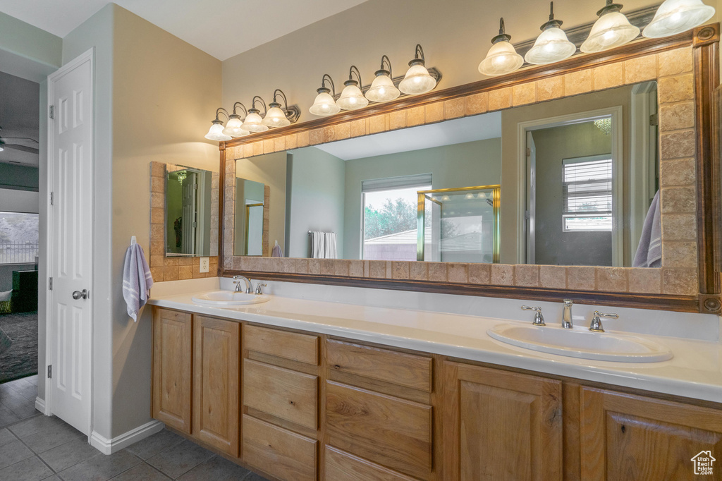Full bathroom with a sink, tile patterned floors, a shower with shower door, and double vanity