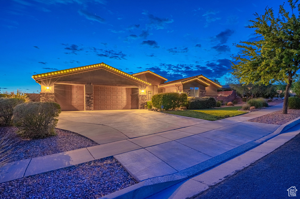 Ranch-style home with a garage, stone siding, stucco siding, concrete driveway, and a tile roof