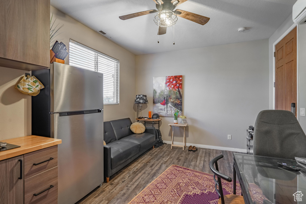 Office featuring a wall mounted air conditioner, a ceiling fan, baseboards, visible vents, and dark wood-style floors