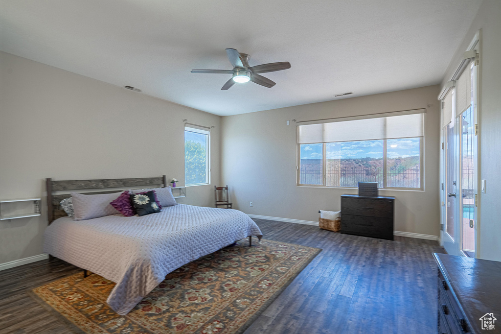 Bedroom with baseboards, ceiling fan, wood finished floors, and visible vents