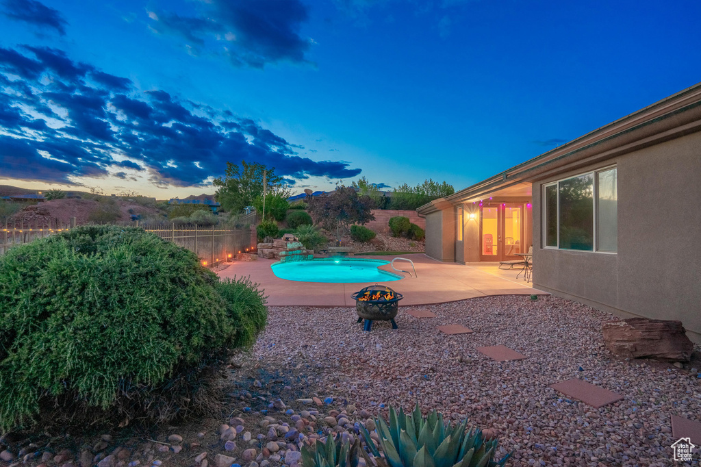 Pool at dusk featuring a patio, fence, and a fenced in pool