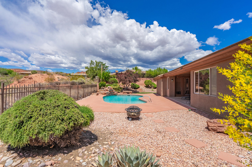 View of swimming pool with a fenced in pool, a fenced backyard, a fire pit, and a patio