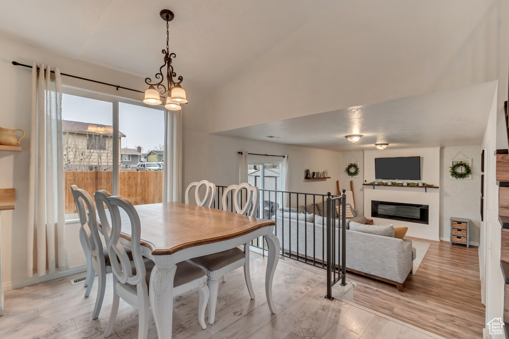 Dining room featuring lofted ceiling, plenty of natural light, and light wood-type flooring