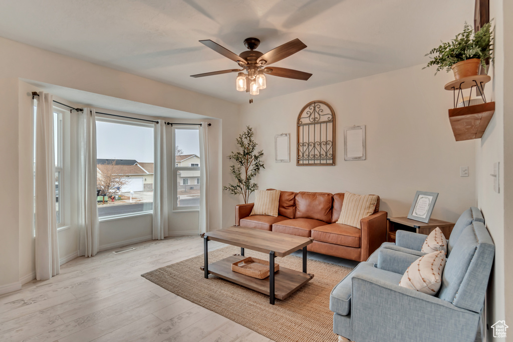 Living room with ceiling fan and light wood-type flooring