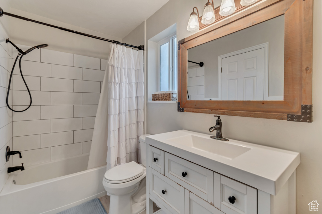 Full bathroom with shower / tub combo with curtain, vanity, and toilet