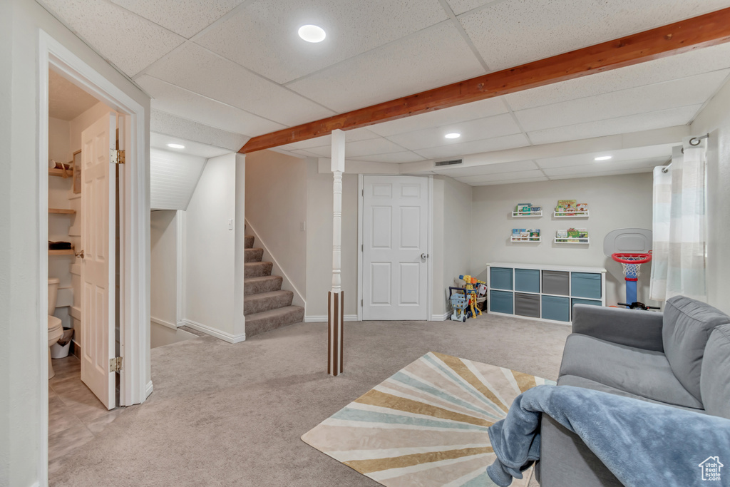 Carpeted living room with a drop ceiling