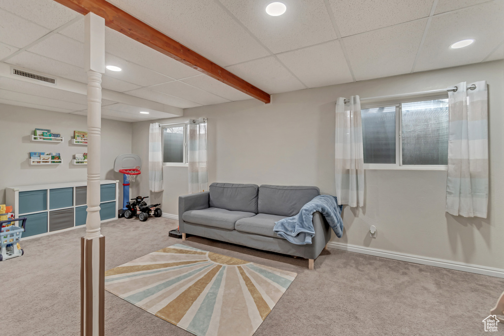 Carpeted living room with beam ceiling, a paneled ceiling, and decorative columns