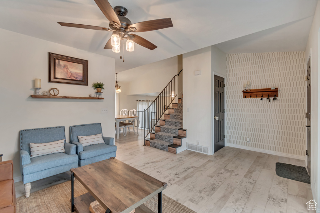 Living room with light hardwood / wood-style flooring and ceiling fan