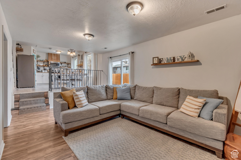 Living room featuring light hardwood / wood-style floors and a textured ceiling