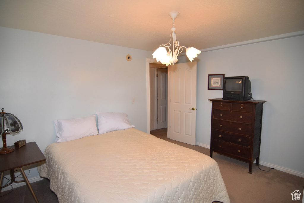 Bedroom with a chandelier, carpet floors, and baseboards