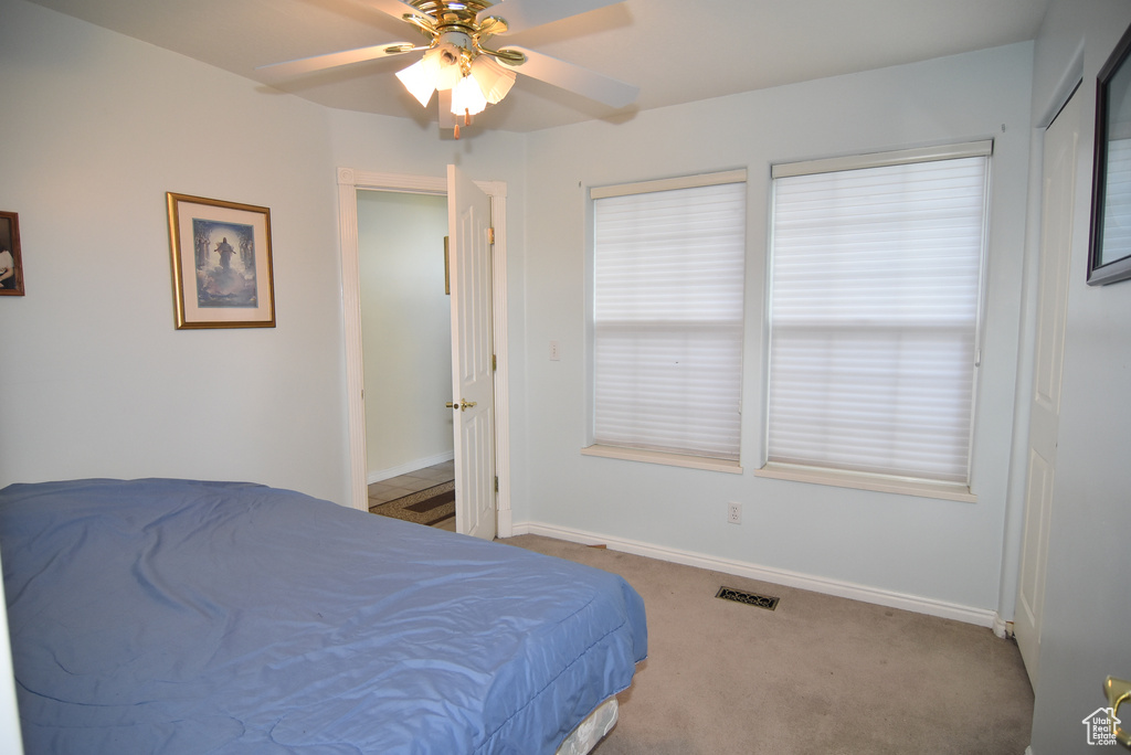 Carpeted bedroom featuring baseboards and ceiling fan