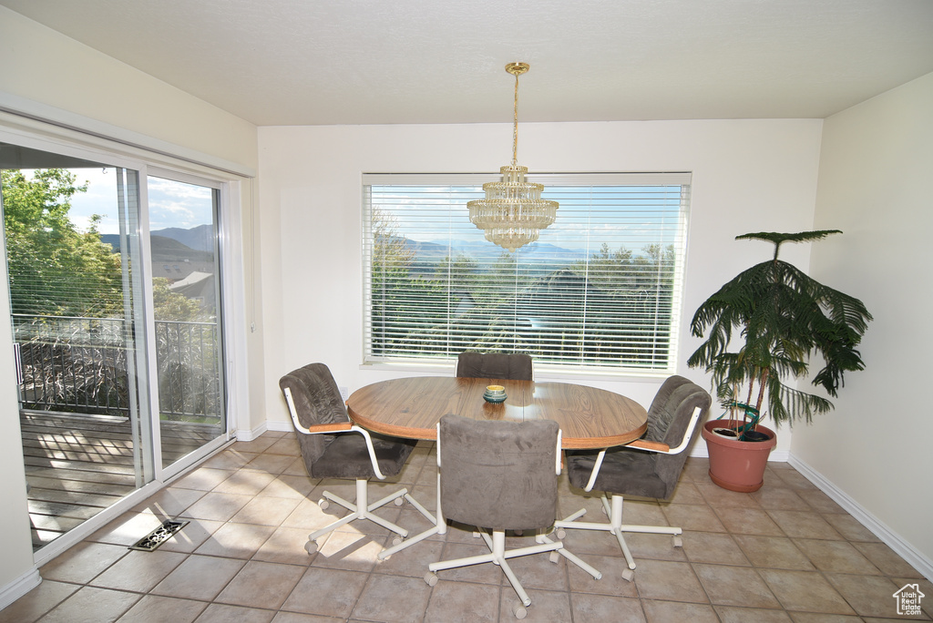 Dining space featuring plenty of natural light, a chandelier, and baseboards