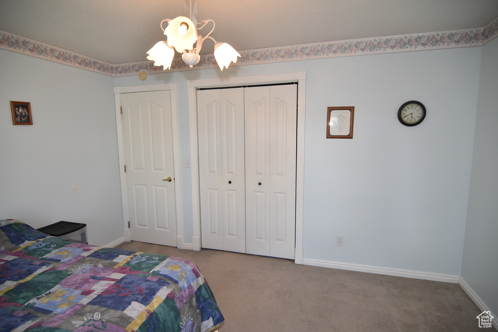 Carpeted bedroom with a closet and baseboards