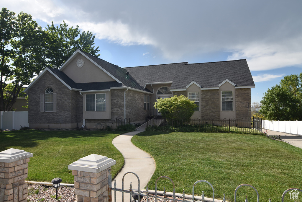 Ranch-style home with roof with shingles, fence private yard, a front lawn, and brick siding