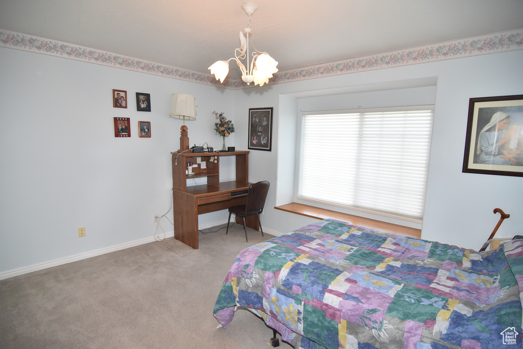 Bedroom with a chandelier, carpet flooring, and baseboards